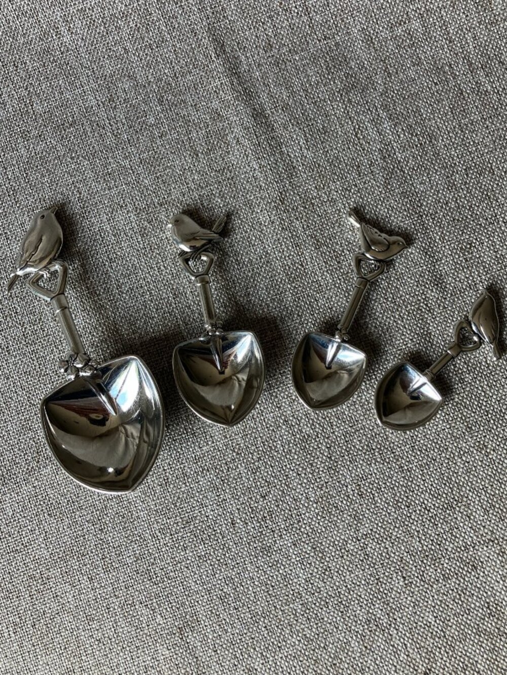 4-Piece Ganz Measuring Spoons featuring shovel-shaped bowls and bird handles